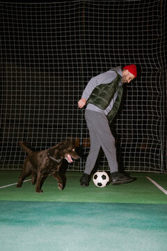 Adult man playing ball with his dog