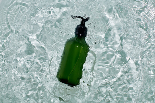 Transparent Plastic Bottle Of Shower Gel Lying On Water
