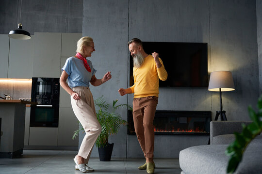 Full length of loving senior couple dancing at home