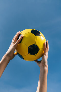 Human's hands holding a soccer ball