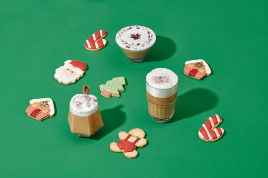 Christmas decorations, coffee cup and cinnamon on green background