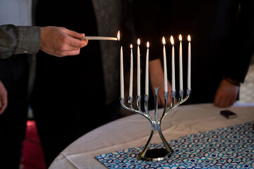 Hanukkah: Teen Male Lighting Candles In Menorah