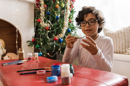 Child painting a Christmas sphere. 
