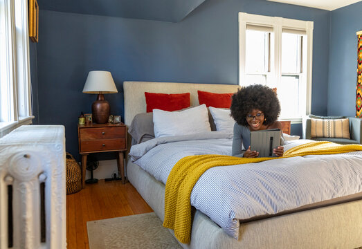 Black Girl house on video chat with ipad tablet computer in bedroom 