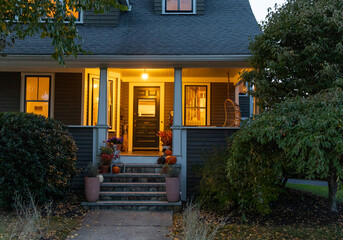 Exterior front of home with porch at dusk with Halloween decorations 