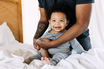 A father changing his baby's clothes