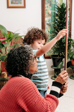 Grandmother showing violin bow to grandson