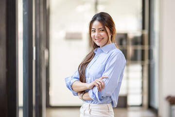 Portrait of Young confident smiling Asian business woman leader, successful entrepreneur, elegant professional company executive ceo manager, standing in office.