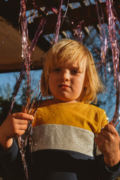 A kid in a A Shiny Silver Foil Fringe Curtain

