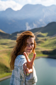 Happy Woman in the mountain making peace sign