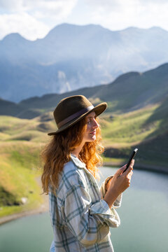 Woman using phone in the mountain