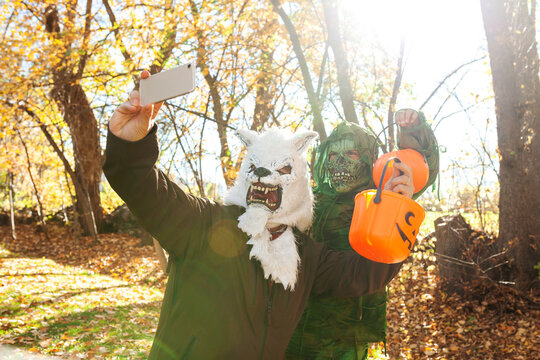 Father and son disguised on Halloween taking selfies