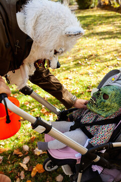Dad and toddler on stroller wearing terrifying masks