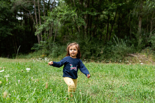 Cute girl running by the meadow