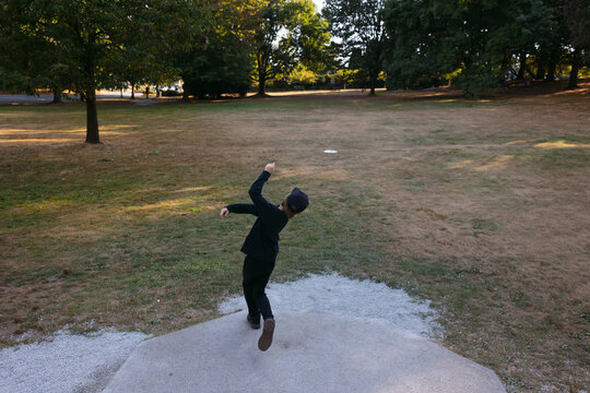 Young disc golfer teeing of with driver disc.