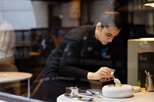 Focused chef woman preparing food in cozy restaurant