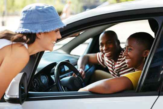 Woman speaking with cheerful friends in car