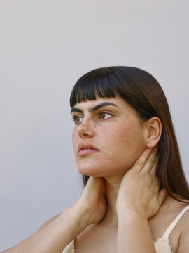 Woman applying skincare product to her neck