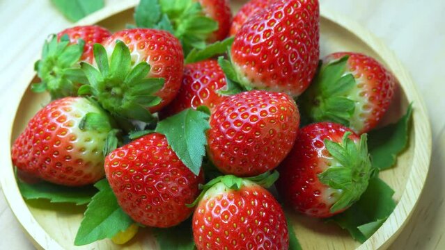 Fresh Red strawberry in wooden plate on wooden background, Red Pink snow Strawberries on wooden Background. 