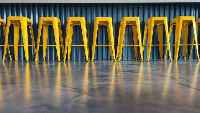 Row of bright yellow bar stools low angle at bar