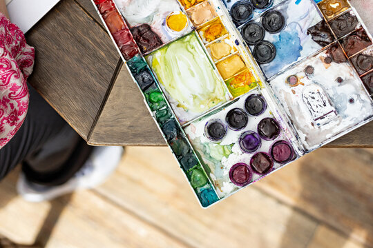 Close up of watercolor paintings container of woman artist