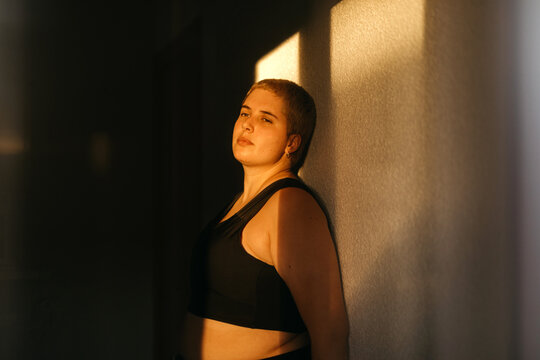 Non binary person standing in sunlight