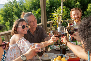 Couple toasting friends while celebrating at a dinner party outside
