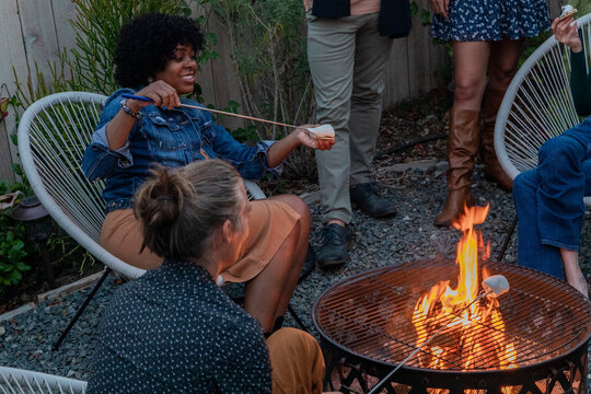 Friends hanging out together by a firepit in an urban yard 