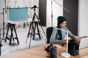 Muslim photographer using laptop in studio