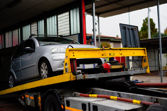 Car on tow truck at the repair workshop