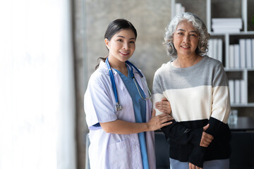Young female doctor provide care medical service help support smiling old grandma at homecare...