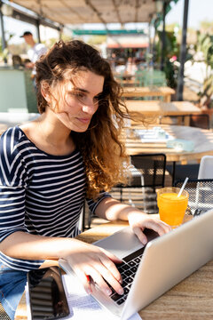 Young woman studying at terrace bar