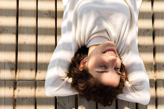 Relaxed woman lying on wooden floor outdoor