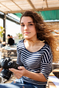 Young photographer woman at terrace bar