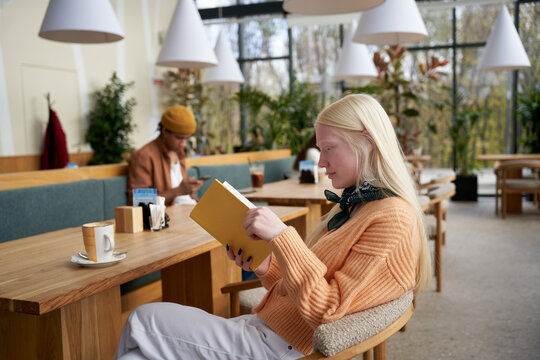 Smiling female bookworm reading book
