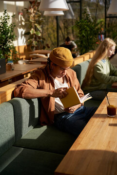 Casual Man Relaxes Reads Book In Cafe Restaurant