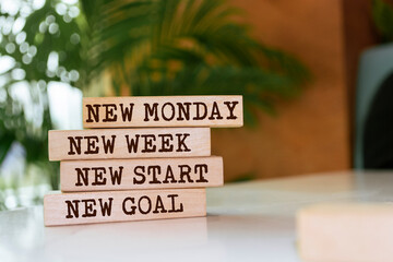 Wooden blocks with words 'New Monday, New week, new start, new goal'.