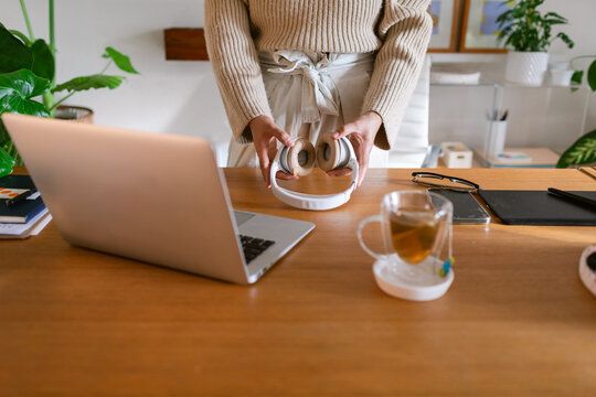 Crop woman catching headphone at office desk