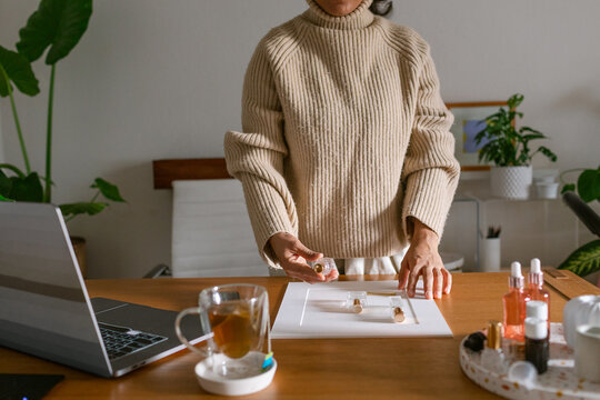 Cropped perfumer taking product photo at office
