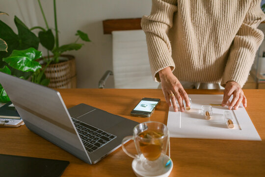 Perfumer woman taking product photo at desk