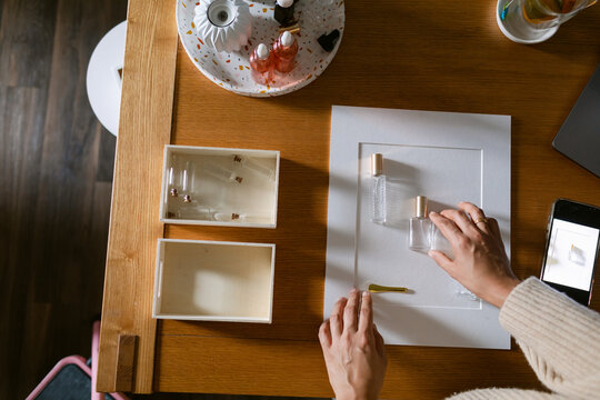 woman arrangements perfume bottles to photograph