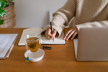 Woman writing at home office desk