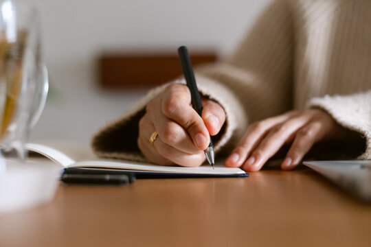 Female writing on notebook closeup