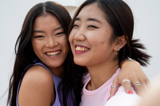 Two Happy Asian Female Friends hugging