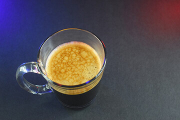 hot black coffee on black table with neon lights