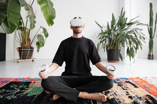 Man doing yoga with vr glasses
