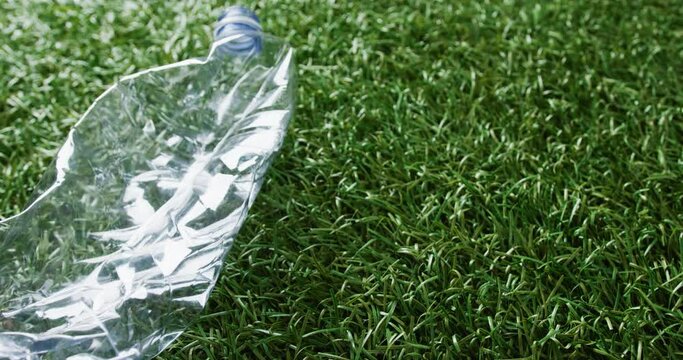 Close up of plastic bottle trash on grass background, with copy space