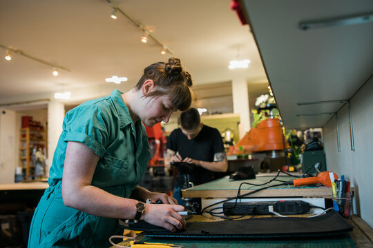 Two people working in a shoe repair shop.
