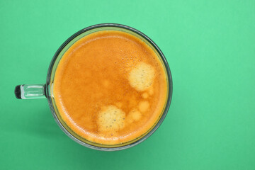 glass of hot black coffee put on green background