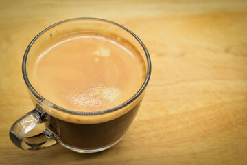 glass of hot black coffee put on wood background